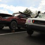Two modified vehicles, a red sports car and a grey truck, equipped with heart-shaped headlights, parked next to each other at a cars+coffee event.